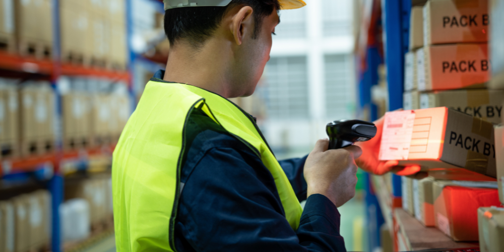 Warehouse worker scanning inventory on shelving
