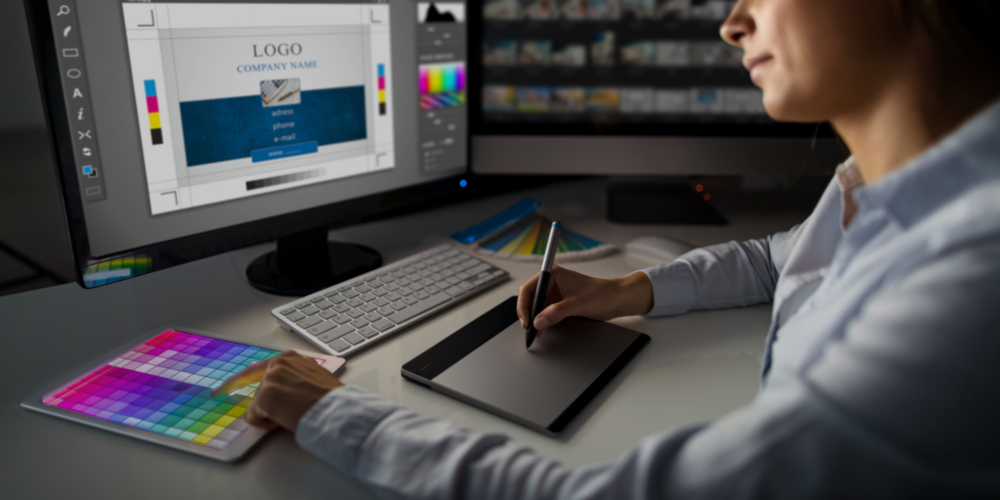 designer creating branded artwork on dual monitors